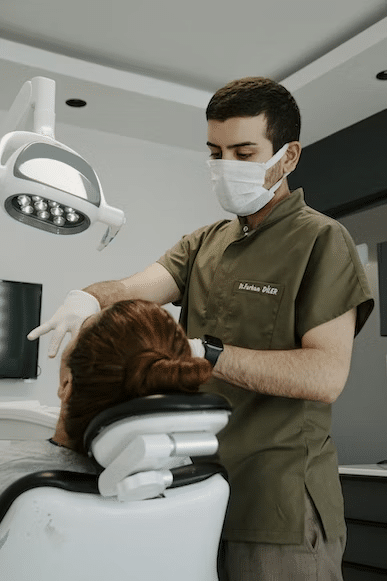 a dental professional performing a dental procedure on his patient