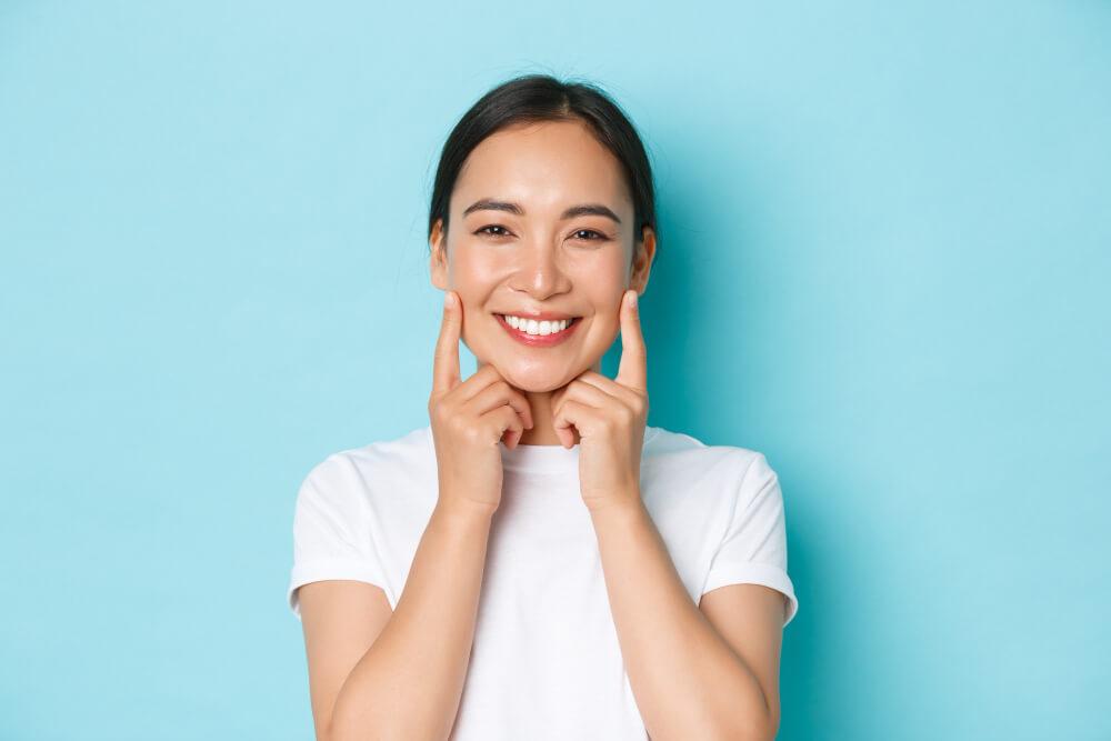 a female in white shirt smiling widely