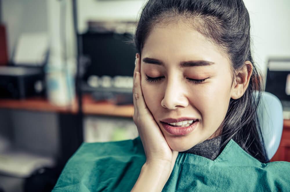 woman with toothache touching her cheeks