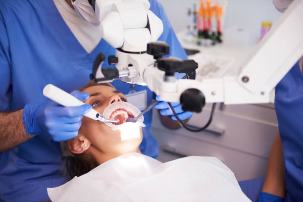 a female patient with her mouth wide open receiving dental care from a dentist