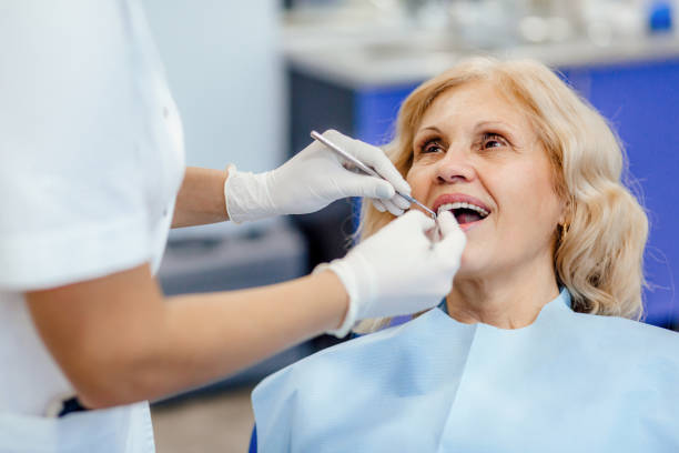 an elderly woman receiving dental care from a dentist