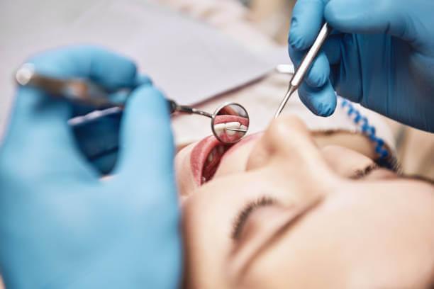 a dentist performing a thorough dental checkup for an emergency patient in a clinic