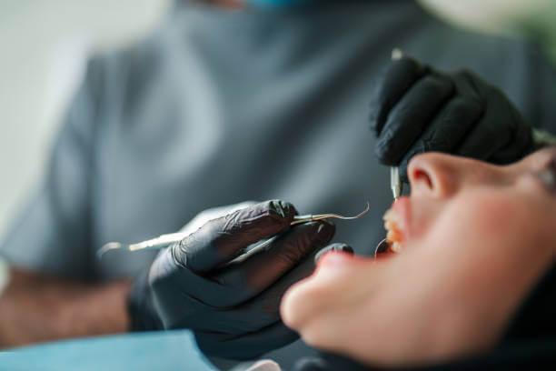 a dentist providing emergency dental treatment to a patient in a modern dental clinic
