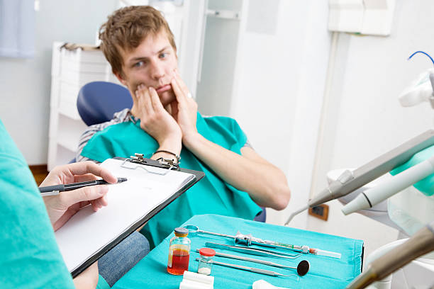 a man touching both his jaw due to dental emergency