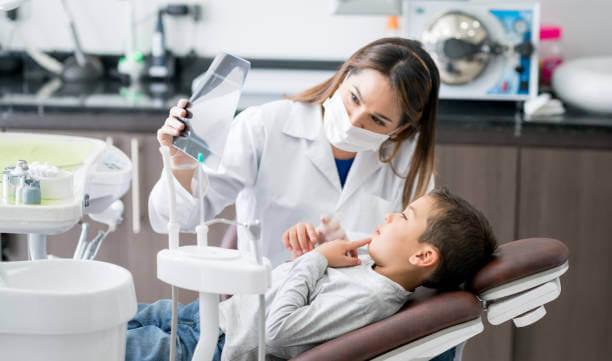 a dentist carefully checks a child's molars through a dental x-ray
